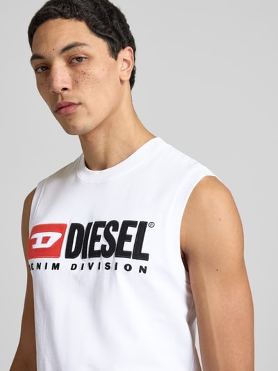 Męski model nosi Tanktop mit Label-Detail od Diesel z bawełny, krój regular fit, prążkowane wykończenia, okrągły dekolt, detal z logo; zbliżenie na górną część ciała.