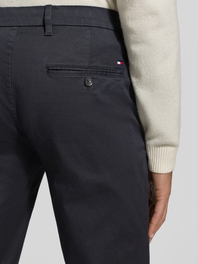 Männermodel trägt Slim Fit Chino aus Baumwoll-Mix Modell 'BLEECKER' von Tommy Hilfiger, Optik: Unifarben, Detailaufnahme Rückansicht.