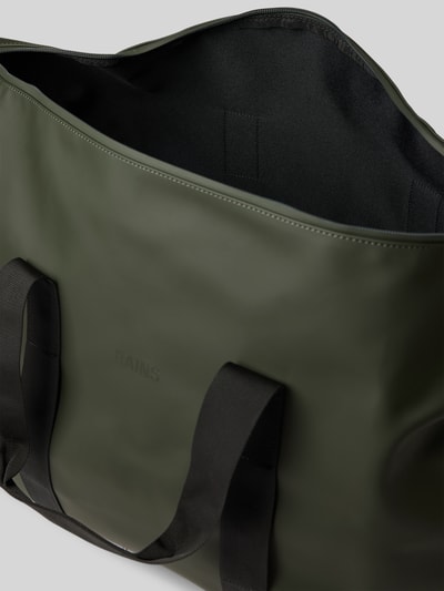 Produktfoto, olijfgroene weekendtas met zwarte schouderband van Rains, Weekend Bag met Logo-Detail Model 'Hilo', Hoofdvak met ritssluiting, afneembare schouderband, breedte 64 cm, lengte 40 cm, diepte 24 cm, bandlengte 84 cm