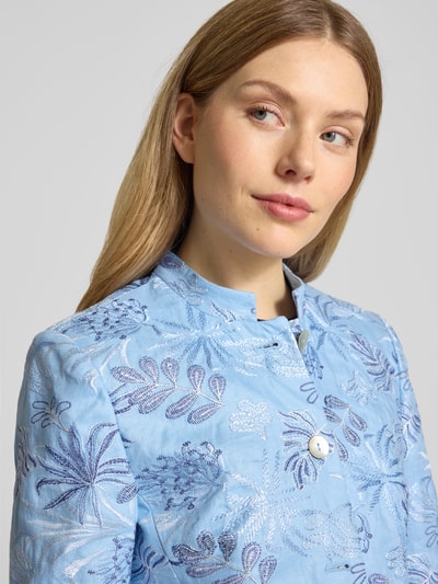 Frauenmodel trägt Slim Fit Longblazer aus Leinen mit Stehkragen von WHITE LABEL, hellblau mit floralen Stitchings, Nahaufnahme Oberkörper. Rückenlänge 80 cm, Brustweite 33 cm, Ärmellänge 62 cm, Größe 36, Knopfleiste.