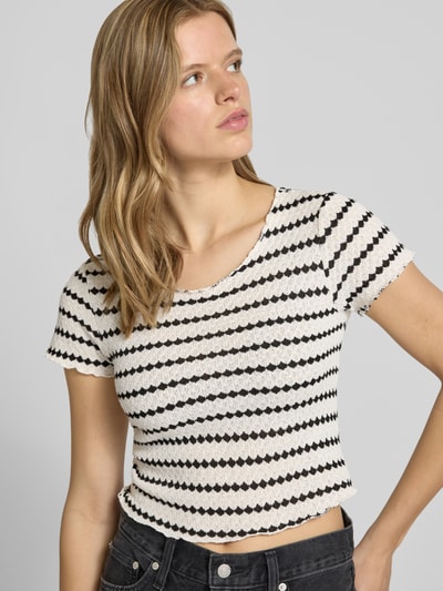 Frauenmodel trägt Slim Fit Crop Top mit Baumwoll-Anteil Modell 'EVA LIFE' von Only im Allover-Muster, Rundhals, Kurzarm, Strick, Nahaufnahme Oberkörper.