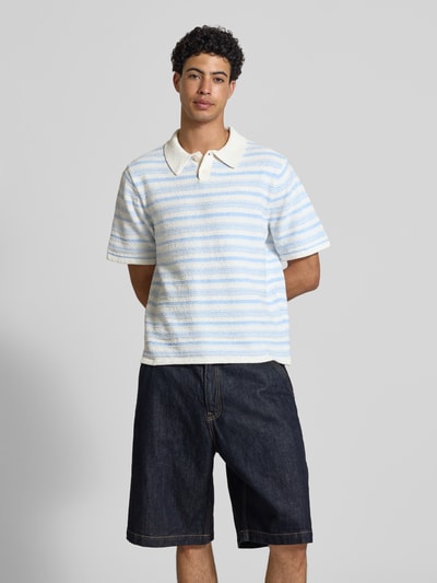 Männermodel trägt Modern Fit Poloshirt mit kurzer Knopfleiste Modell 'HYERES' von Jack & Jones, Material-Mix, Strukturmuster, Ganzkörperansicht von vorne.