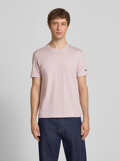 Männermodel trägt T-Shirt mit Label-Stitchings und Rundhalsausschnitt von CHAMPION in zartrosa, Reine Baumwolle, Regular-Fit, Ganzkörperansicht von vorne. Rückenlänge bei Größe M: 69 cm.