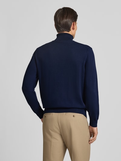 Männermodel trägt Regular Fit Pullover aus reiner Baumwolle von Lacoste in Dunkelblau, strukturierte Optik, Ganzkörperansicht Rückansicht. Herren Turtleneck-Pullover von Lacoste.
