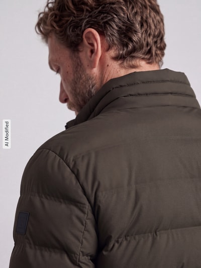 Männermodel trägt Regular Fit Steppjacke mit Stehkragen Modell 'MODENA FUSED' von Strellson in Olivgrün, Nahaufnahme Rückansicht, Herren Steppjacke von Strellson, KI-modifiziertes Bild.
