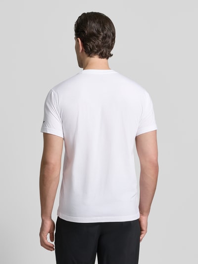 Męski model nosi Slim Fit T-Shirt mit Rundhalsausschnitt von Fabletics, biały, krój slim fit, elastyczna mieszanka bawełny z modalem, krótki rękaw, długość tyłu w rozmiarze M: 68 cm, gładka faktura, całkowity widok z tyłu.