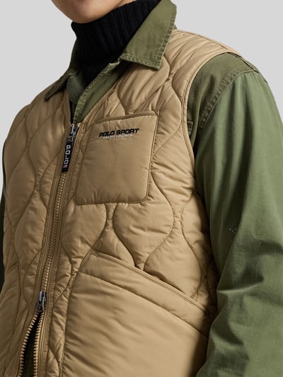 Männermodel trägt Regular Fit Steppweste mit Brusttasche von Polo Ralph Lauren in Beige, unifarben, Nahaufnahme Oberkörper.