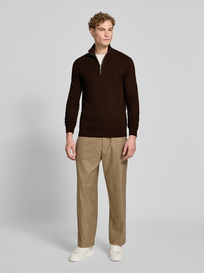 Männermodel trägt Regular Fit Troyer aus reiner Baumwolle Modell 'DANE' von Selected, dunkelbraun, kombiniert mit beigen Karohosen, Herren Troyer von Selected, Ganzkörperansicht von vorne.