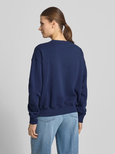 Vrouwenmodel draagt Oversized Sweatshirt aus Baumwoll-Mix van Polo Ralph Lauren, look: effen, pasvorm: oversized, logodetail, ronde hals, lange mouw, rompzoom, materiaalverwerking: sweat, katoenmix, kleur donkerblauw, textuur glad, structuur geribd bij boorden. Ganzkörperansicht Rückansicht.