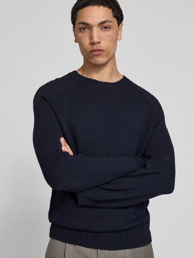 Männermodel trägt Regular Fit Pullover in Strick-Optik von Closed, Reine Baumwolle, Rundhalsausschnitt, elastische Abschlüsse, Nahaufnahme Oberkörper.