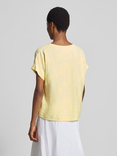 Frauenmodel trägt Regular Fit T-Shirt aus Viskose-Mix Modell 'Anni' von ZABAIONE mit floralem Stitching in hellem Gelb, Ganzkörperansicht Rückansicht.