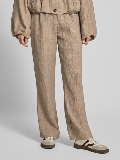 Frauenmodel trägt Stoffhose aus Viskose-Mix mit elastischem Bund von YAS, Wide-Leg-Pants Modell RINA, beige, strukturierte Textur, Nahaufnahme Unterkörper.