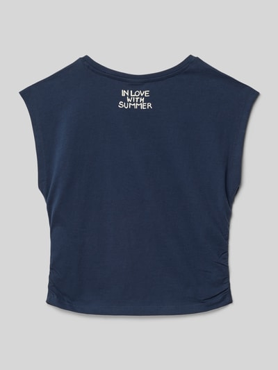 Mädchen trägt V-Shape T-Shirt aus reiner Baumwolle von s.Oliver RED LABEL in Dunkelblau, unifarben, Statement Print, Ganzkörperansicht Rückansicht.