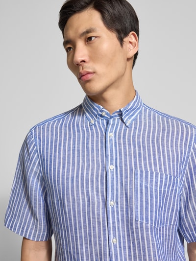 Männermodel trägt Regular Fit Freizeithemd aus Leinen von Christian Berg Men, blau-weiß gestreift, Button-Down-Kragen, Nahaufnahme Oberkörper.