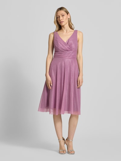 Frauenmodel trägt Knielanes Cocktailkleid mit V-Ausschnitt von TROYDEN COLLECTION, Mesh, Taillierter Schnitt, Knielänge, Schimmernd, Drapierungen, Rückenlänge bei Größe 36: 88 cm, Brustweite bei Größe 36: 36 cm, Ganzkörperansicht von vorne.