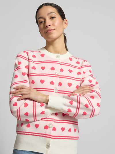 Modelka nosi Regular Fit Cardigan mit Allover-Motiv-Stitching Modell 'Brielle' od ICHI, imitacja dzianiny, motyw serc, listwa guzikowa, okrągły dekolt, elastyczne wykończenia, długość tyłu 57 cm, długość rękawa 60 cm, widok całej sylwetki z przodu.