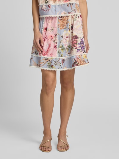 Frauenmodel trägt Minirock mit Spitze Modell 'MESSA' von YAS, florales Muster in Rosa und Blau, A-Linie, Leinen-Baumwoll-Mix, Nahaufnahme Oberkörper.