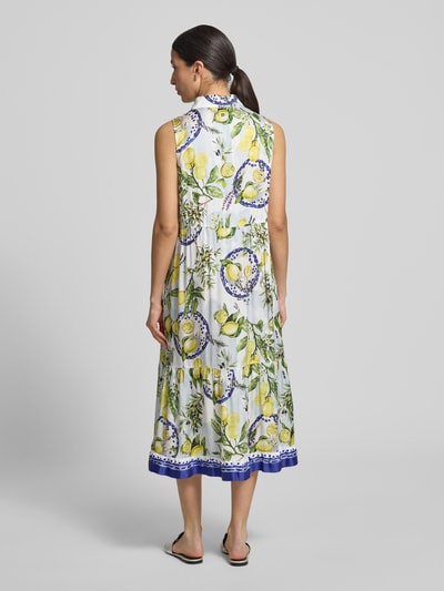 Frauenmodel trägt Hemdblusenkleid aus Reine Viskose mit Knopfleiste von Marc Cain, Taillierter Schnitt, Midikleid, Hemdblusenkragen, Stufenrock, Rückenlänge bei Größe 36: 116 cm, Brustweite bei Größe 36: 50 cm, Ärmellänge bei Größe 36: 9 cm, floraler Print in Gelb, Grün, Blau, Ganzkörperansicht Rückansicht.