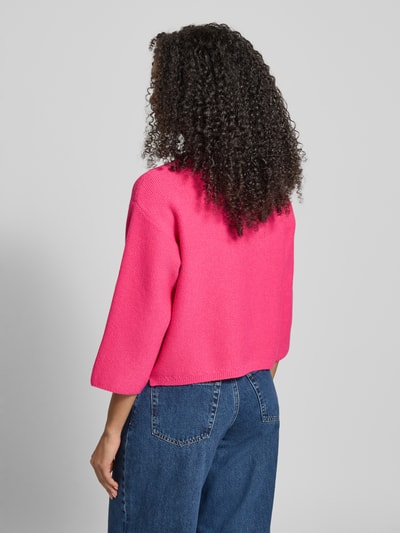 Männermodel trägt Oversized Strickpullover aus Mieszanka wiskozy mit Stójka von More & More, kolor różowy, Ganzkörperansicht Rückansicht, kontext: Damski Sweter z dzianiny, Mieszanka wiskozy, Oversized, Stójka, opuszczone ramiona, długość tyłu w rozmiarze 36: 51 cm, długość rękawa w rozmiarze 36: 41 cm.