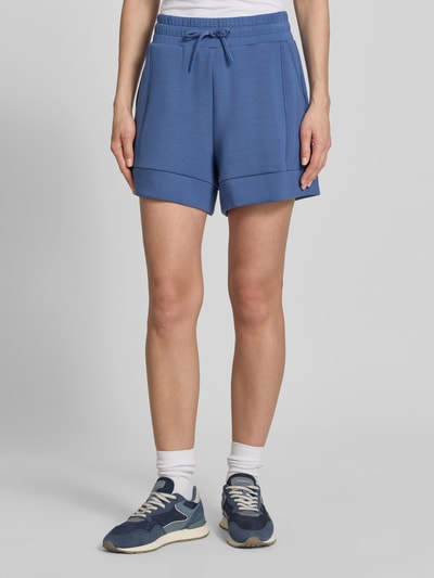 Frauenmodel trägt Shorts mit Eingrifftaschen Modell 'atrium' von VARLEY, Blau, Viskose-Mix mit Stretch-Anteil, High-Rise-Fit, Elastischer Bund mit Kordelzug, Ganzkörperansicht von vorne.