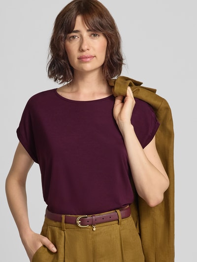 Frauenmodel trägt Regular Fit T-Shirt aus Lyocell-Mix Modell 'AVA' von VERO MODA in Dunkellila zu senfgelber Hose, Nahaufnahme Oberkörper. Damen T-Shirt von VERO MODA.