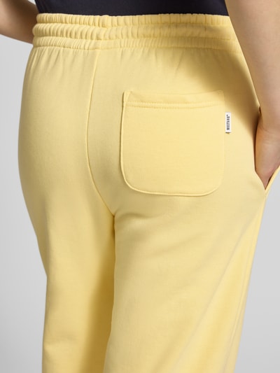 Vrouwenmodel draagt Regular Fit Sweatpants met achterzak model 'Nucia' van Mustang in lichtgeel, puur katoen, steekzakken, elastische band met tunnelkoord, elastische boorden, detailopname achterkant