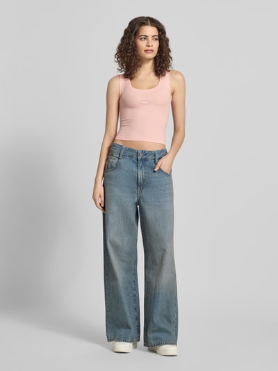 Frauenmodel trägt Slim Fit Top mit Logo-Detail von ANOTHER COTTON LAB, rosa, elastischer Baumwoll-Mix, Ganzkörperansicht von vorne.