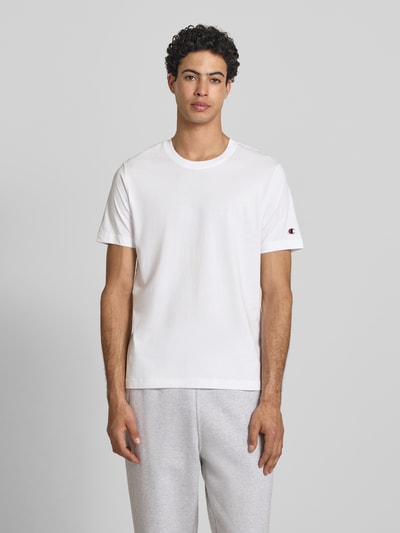Männermodel draagt T-shirt met ronde hals in set van 2 van CHAMPION, puur katoen, regular fit, labeldetail, ruglengte bij maat M 69 cm, vooraanzicht bovenlichaam