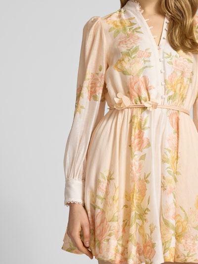 Frauenmodel trägt Cocktailkleid mit Bindegürtel Modell 'Shannah' von Forever New aus Reine Baumwolle mit floralen Pastellfarben, A-Linie, Minikleid, Stehkragen, Knopfleiste, Detailaufnahme Oberkörper.