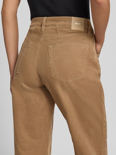 Frauenmodel trägt Tapered Fit Cordhose aus Baumwoll-Mix Modell 'MILEY' von Brax in beige mit sichtbarer Struktur, Nahaufnahme Rückansicht, Damen Cordhose von Brax.