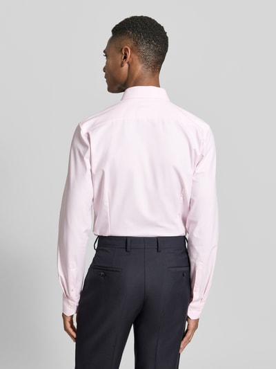 Männermodel trägt Super Slim Fit Business-Hemd Modern Kent Uni Twill von OLYMP No. Six in Hellrosa, glatter Twill, Rückenansicht Ganzkörperansicht. Elastischer Baumwoll-Mix, schmale Passform, Knopfleiste, schlichte Farbtöne.