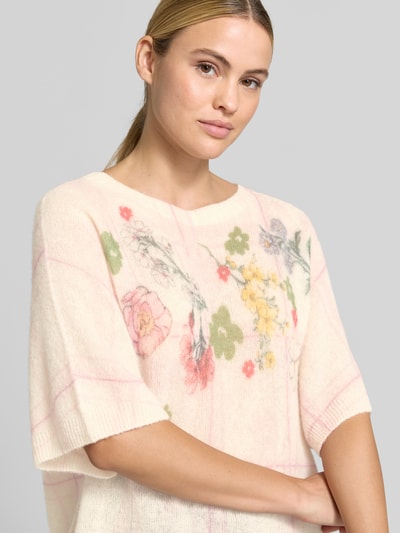 Kobiece modelka nosi Relaxed Fit Pullover aus Alpaka-Mix od Marc Cain, Mieszanka wełny z alpaki z dodatkiem wełny, Imitacja dzianiny, Dekolt w serek, Rękaw o dł. 1/2, Długość tyłu w rozmiarze 36: 53 cm, Długość rękawów w rozmiarze 36: 38 cm, jasne kolory, kwiatowy wzór, miękka tekstura, Nahaufnahme górnej części ciała.