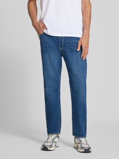 Mężczyzna nosi Straight Fit Jeans aus Baumwoll-Mix Modell 'CHRIS' von JACK & JONES, mieszanka bawełny, krój straight fit, 5 kieszeni, zapięcie na guzik i zamek błyskawiczny, szerokość w rozmiarze 32/32: 41 cm, długość wewnętrzna nogawki 72 cm, granatowy denim, widoczne przeszycia, widoczne kieszenie, całkowity widok z przodu.