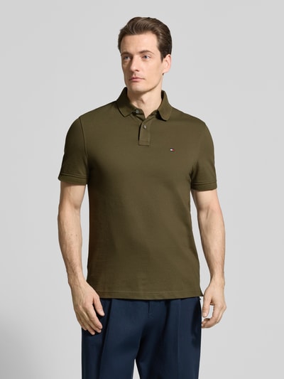 Männermodel trägt Regular Fit Poloshirt aus Baumwoll-Mix von Tommy Hilfiger, Optik:Unifarben, Logo-Stitching, Piqué, Ganzkörperansicht von vorne.