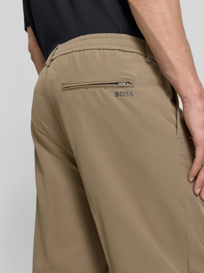Männermodel trägt Tapered Fit Anzughose aus bügelleichtem Material Modell 'T_CONVERT' von BOSS Green, Detailaufnahme Rückansicht.