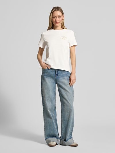 Vrouwenmodel draagt t-shirt met ronde hals en logo van Gant, puur katoen, regular fit, ruglengte bij maat S 56 cm, geheellichaamsaanzicht van voren.