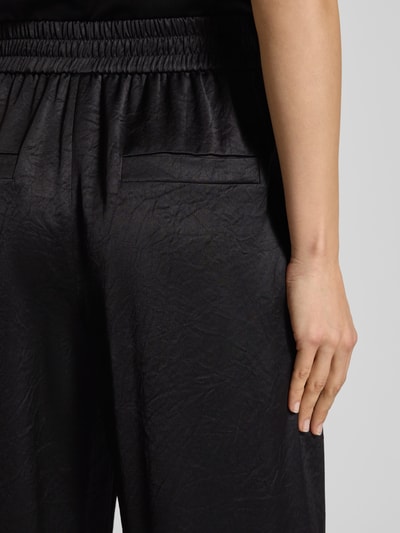 Kobiece model nosi Spodnie materiałowe z kieszeniami z tyłu od Marc Cain, mieszanka acetatu, luźny krój, elastyczny pas, detailaufnahme.