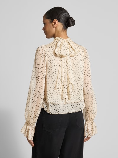 Frauenmodel trägt Regular Fit Bluse im Stufen-Look Modell 'LURDES' von Mango in Creme mit schwarzen Punkten, transparenter Stoff, Stehkragen, Rückenlänge 57 cm, Ärmellänge 76 cm, Ganzkörperansicht Rückansicht.