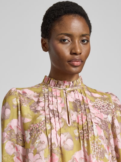 Frauenmodel trägt Regular Fit Hemdbluse mit Rüschenkragen Modell 'Belmira' von JOOP! mit floralen Mustern in Rosa und Grün, Nahaufnahme Oberkörper.