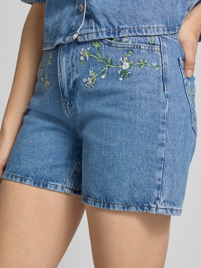 Frauenmodel trägt Regular Fit Jeansshorts aus reiner Baumwolle Modell 'SKY' von Pieces, 5-Pocket-Design, Stickerei, Nahaufnahme Oberschenkel.