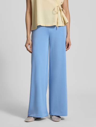 Frauenmodel trägt Sweatpants mit Stretch-Anteil von Milano Italy in Hellblau, lockere Passform, elastischer Bund, weites Bein, Nahaufnahme Unterkörper. Modal-Elasthan-Mix, Eingriff- und Gesäßtaschen sichtbar.
