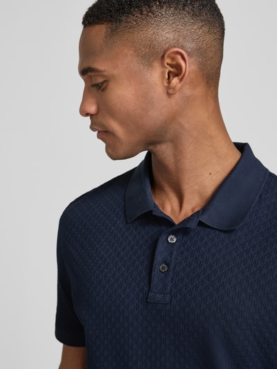 Mannelijk model draagt Poloshirt met korte knoopsluiting model 'Roni' van JOOP! Collection, donkerblauw katoen, regular fit, detailopname bovenlichaam.