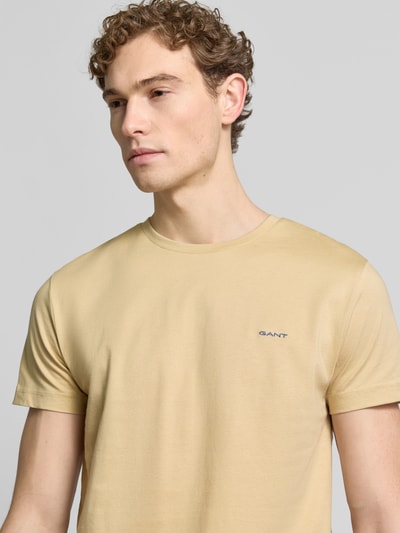 Männermodel trägt T-Shirt mit Label-Detail von Gant in Beige, reine Baumwolle, gerader Schnitt, Nahaufnahme Oberkörper.