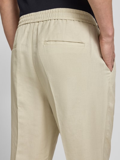 Männermodel trägt Regular Fit Hose aus Leinen-Viskose-Mix Modell 'NEIL' von Antony Morato in Beige mit Bügelfalten, elastischer Bund, Detailaufnahme Rückansicht, Kontext: Herren Hose, Bundweite 44 cm, Innenbeinlänge 74 cm bei Größe 50.