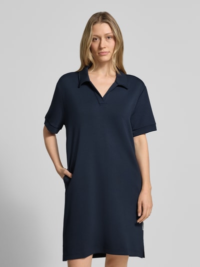 Frauenmodel trägt Regular Fit Polokleid mit Modal-Anteil von Marc O'Polo in Dunkelblau, kurzärmelig, unifarben, Stretch-Material, Ganzkörperansicht von vorne.