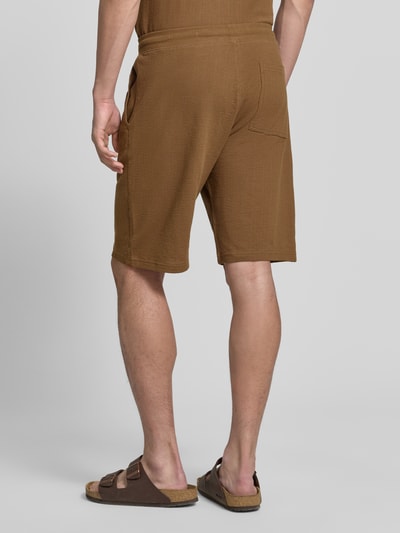 Männermodel trägt Relaxed Fit Sweatshorts aus reiner Baumwolle Modell 'DETROIT' von s.Oliver RED LABEL, Optik: Unifarben, Passform: Relaxed-Fit, fein strukturiertes Muster, Tunnelzug, Bundabschluss: elastisch, seitliche Eingrifftaschen, Gesäßtasche, Material: reine Baumwolle, Ganzkörperansicht Rückansicht.