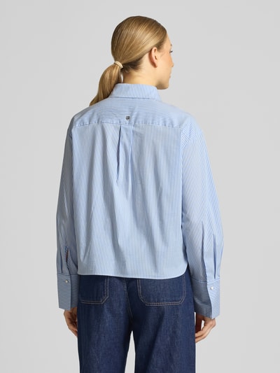 Młodzieżowy model nosi Regular Fit Bluse mit Stitchings von Marc Cain, mieszanka bawełny z dodatkiem streczu, kołnierzyk koszulowy, hafty, długość tyłu w rozmiarze 36: 57 cm, długość rękawów w rozmiarze 36: 59 cm, jasnoniebieskie paski, gładka faktura, krój regular fit, widok całej sylwetki z tyłu.