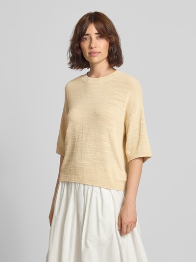 Vrouwenmodel draagt gebreid shirt van MSCH Copenhagen Model 'Lauralynn' in lichtbeige, Mix van biologisch katoen, loose fit, ronde hals, 1/2-mouwen, overlappende schouders, ruglengte maat S/M 53 cm, mouwlengte S/M 22 cm, Ganzkörperaanzicht van voren.
