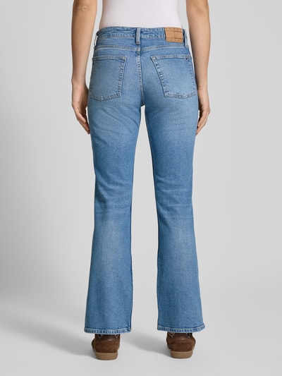 Frauenmodel trägt Regular Fit Bootcut Jeans aus Baumwoll-Mix Modell 'CLEO' von Tommy Jeans, unifarbener Denim, Label Patch, Ganzkörperansicht Rückansicht.