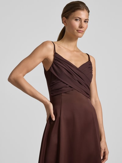 Frauenmodel trägt Abendkleid mit Drapierungen und V-Ausschnitt von Rinascimento aus Satin, Taillierter Schnitt, Maxikleid, Nahaufnahme Oberkörper.